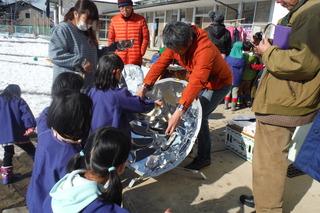 太陽光発電を使った模型の電車の走行を体験し太陽の力について学習している園児の写真