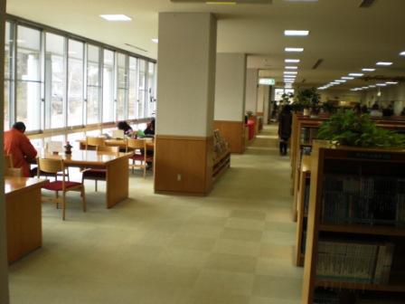図書館内にある明るい閲覧コーナーで閲覧している人の写真